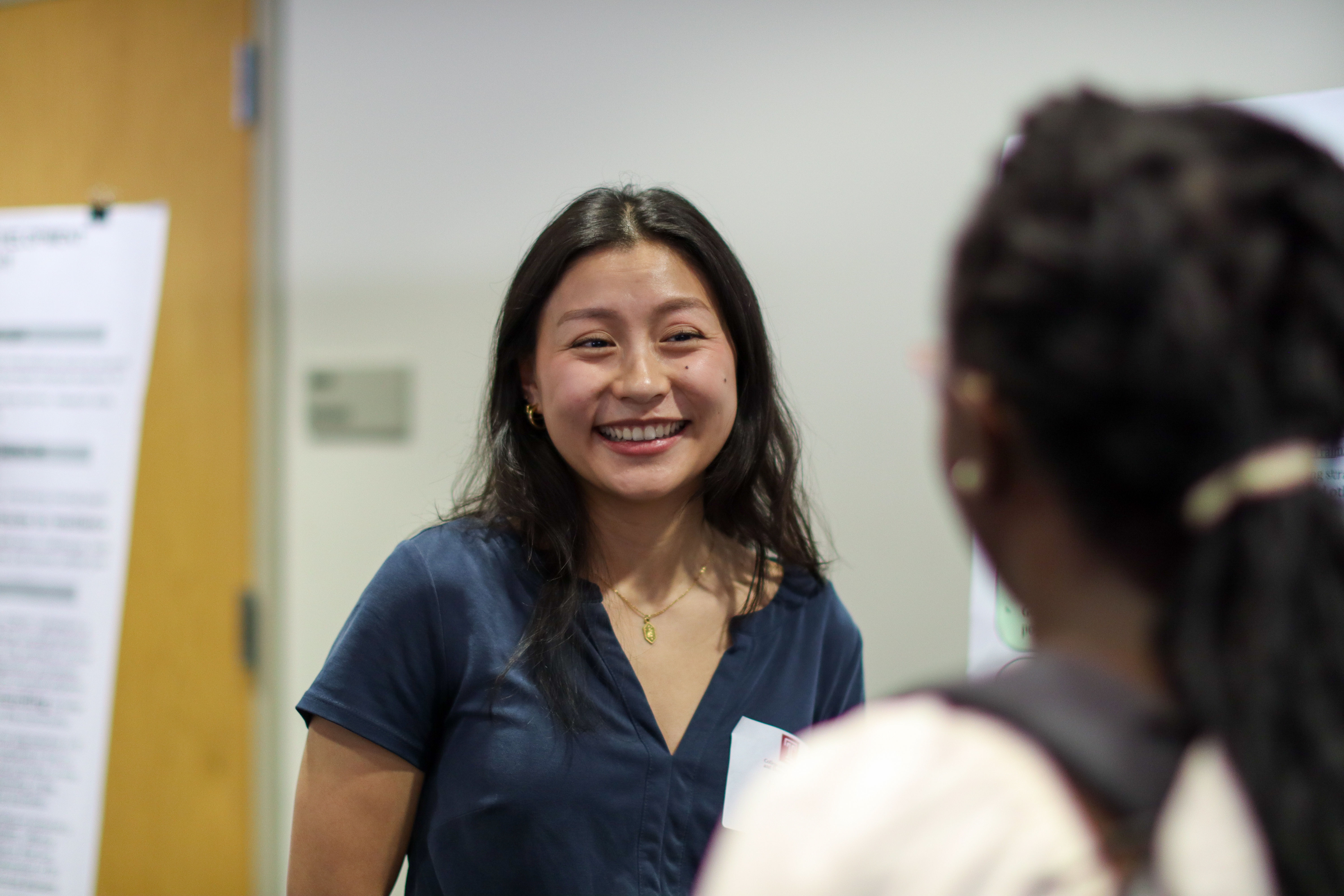 Two female students engage during poster session