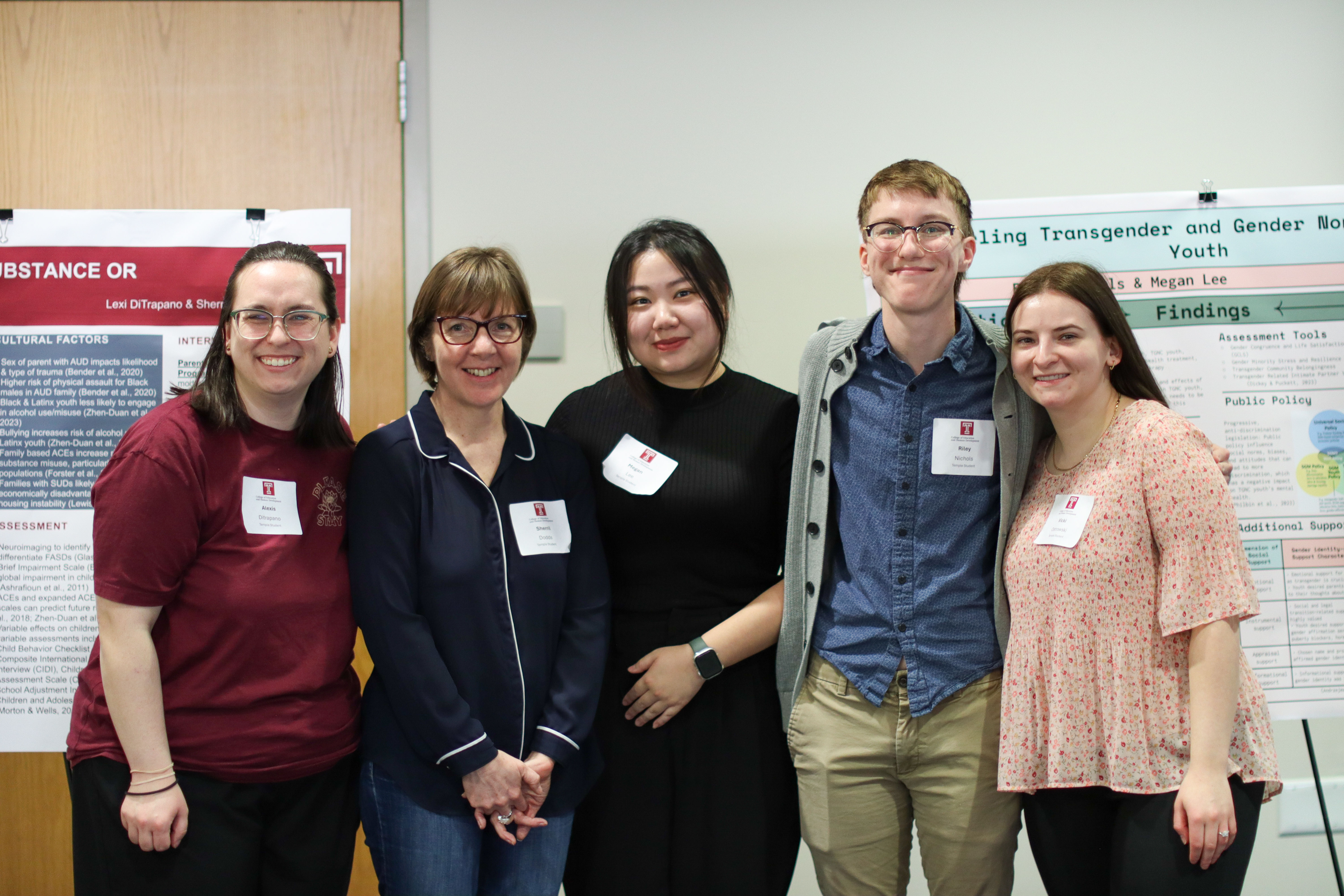 Group of 5 students standing together, posing for a photograph during the poster session