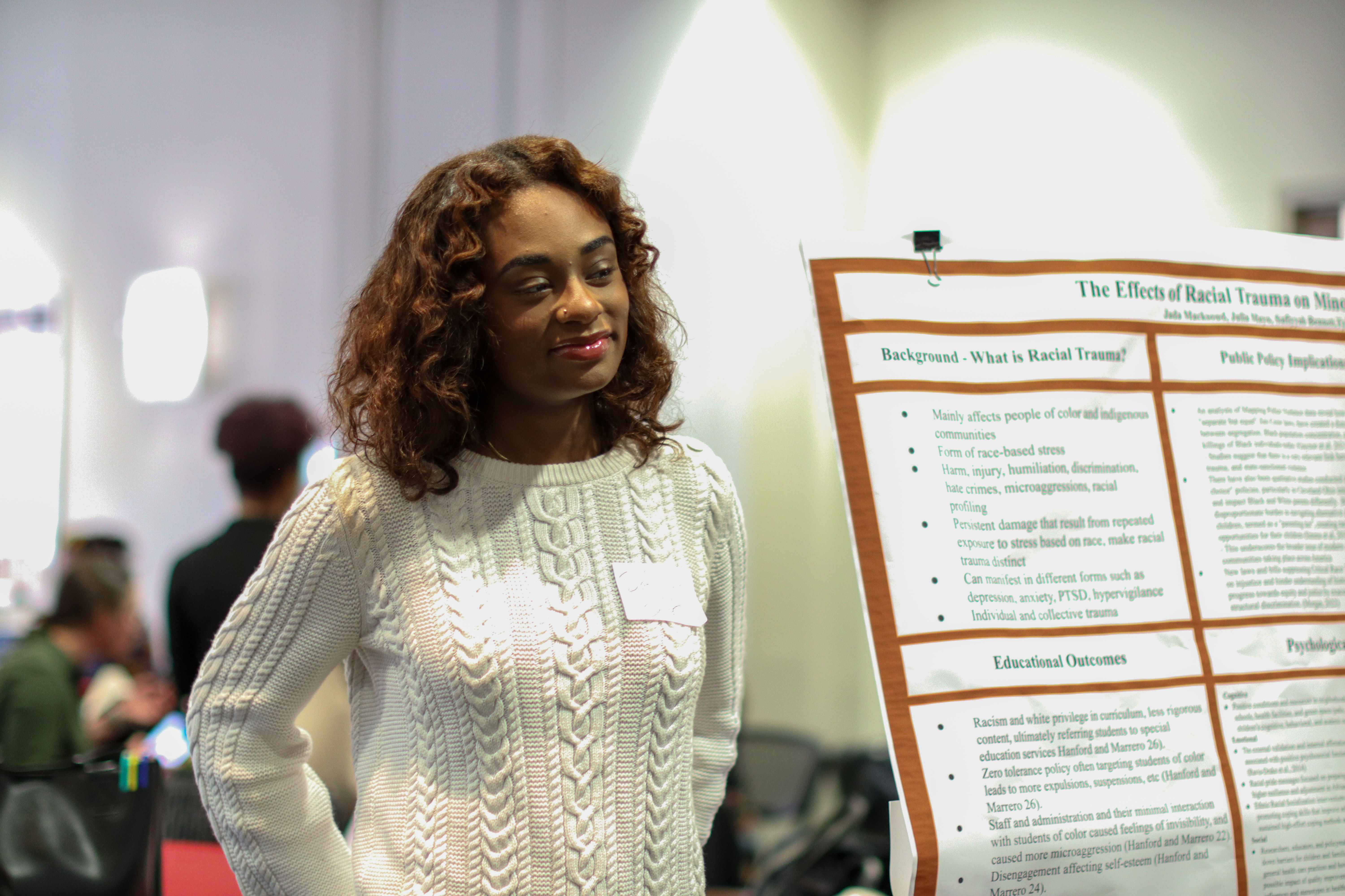 Student standing near poster during poster session