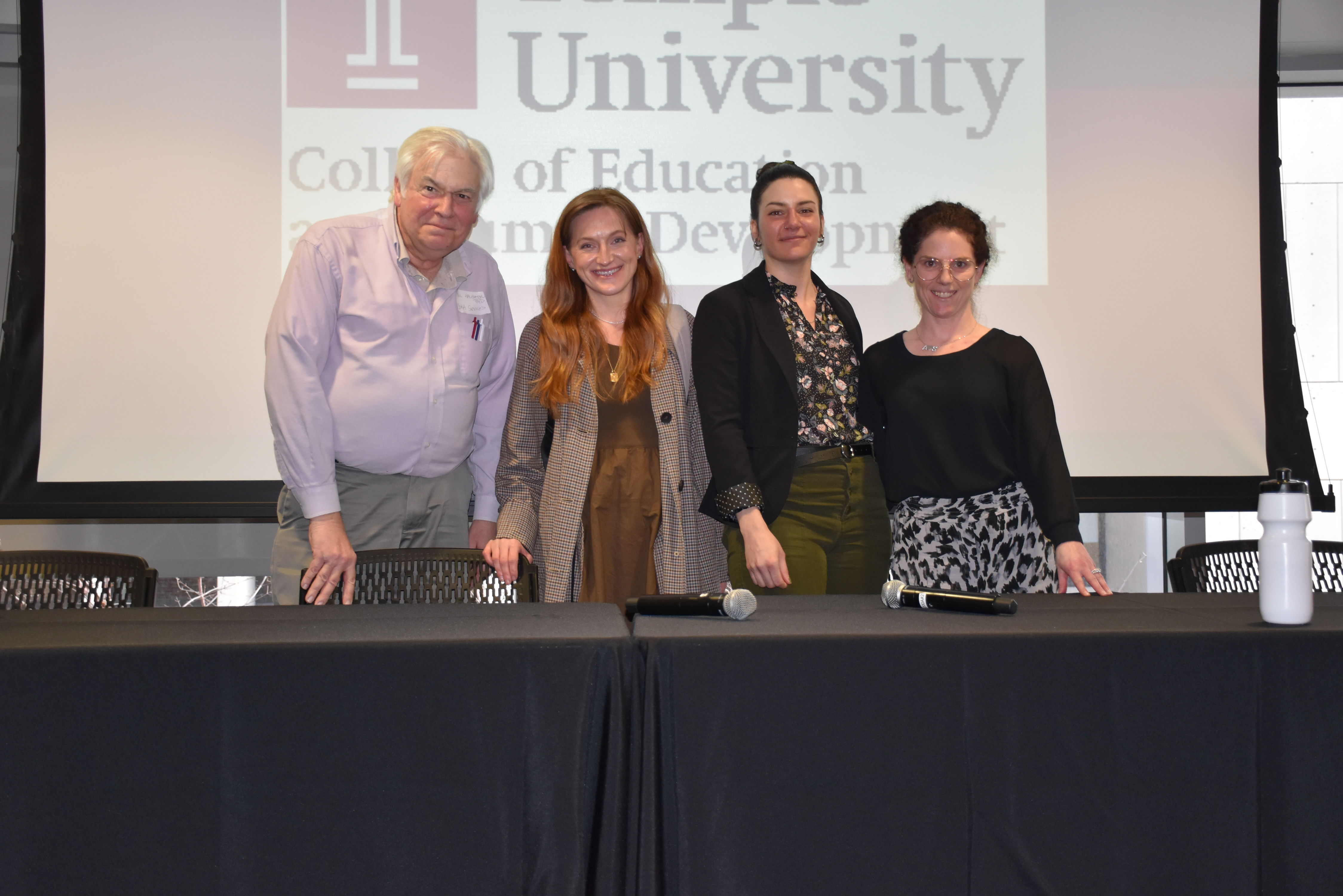 Group of four poses at panelist table