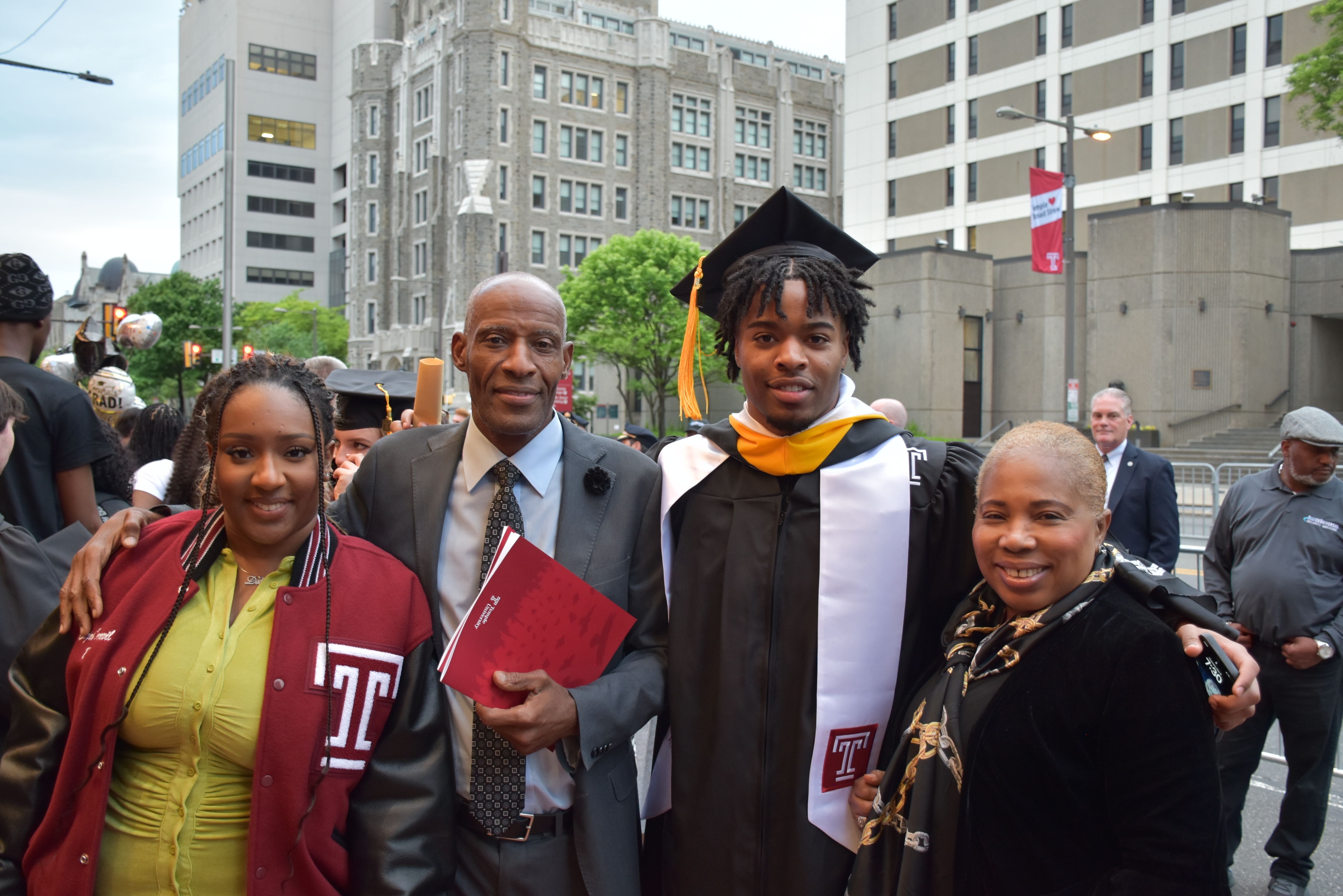 Graduate celebrates with family outside The Liacouras Center after graduation