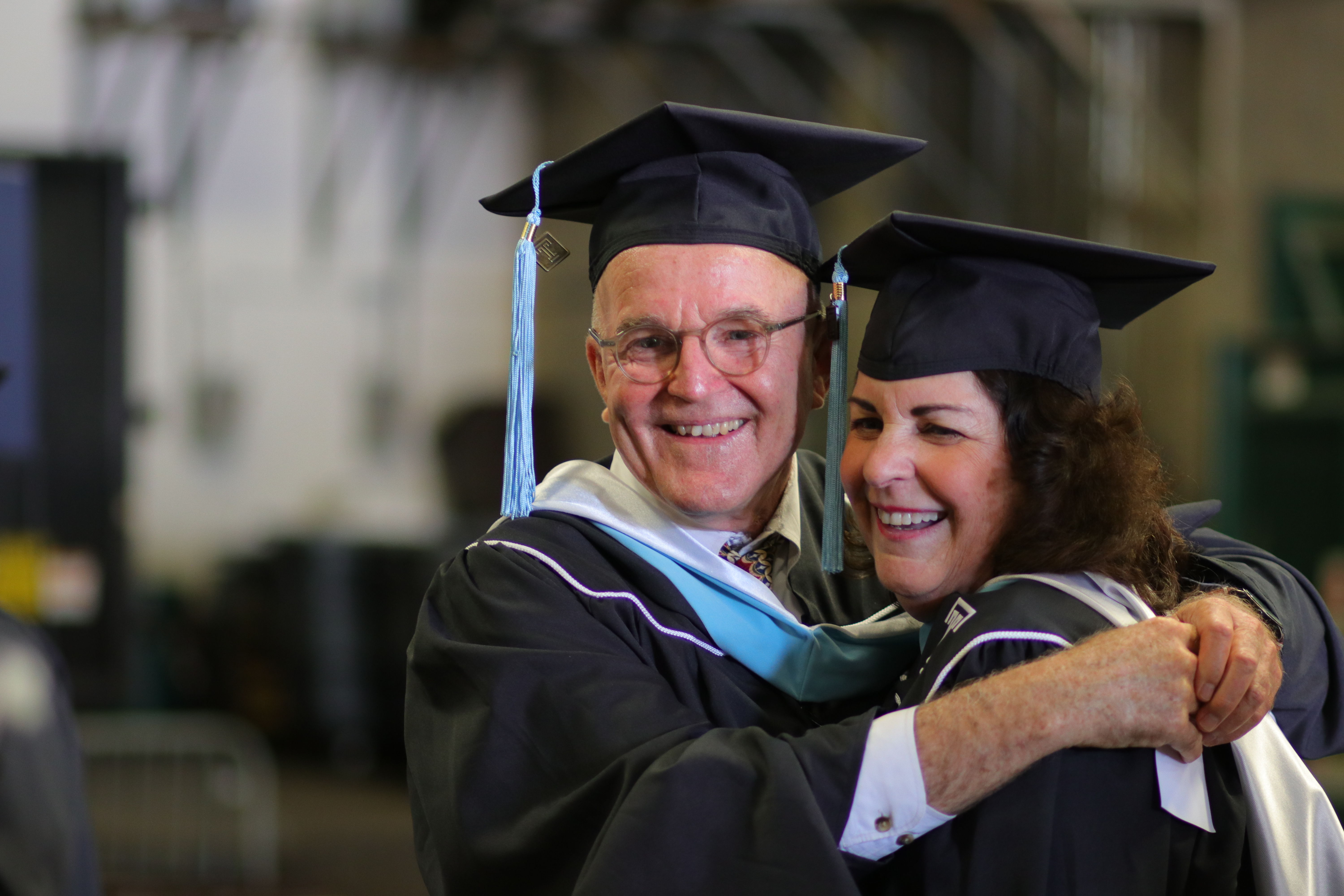 Two graduating students embrace