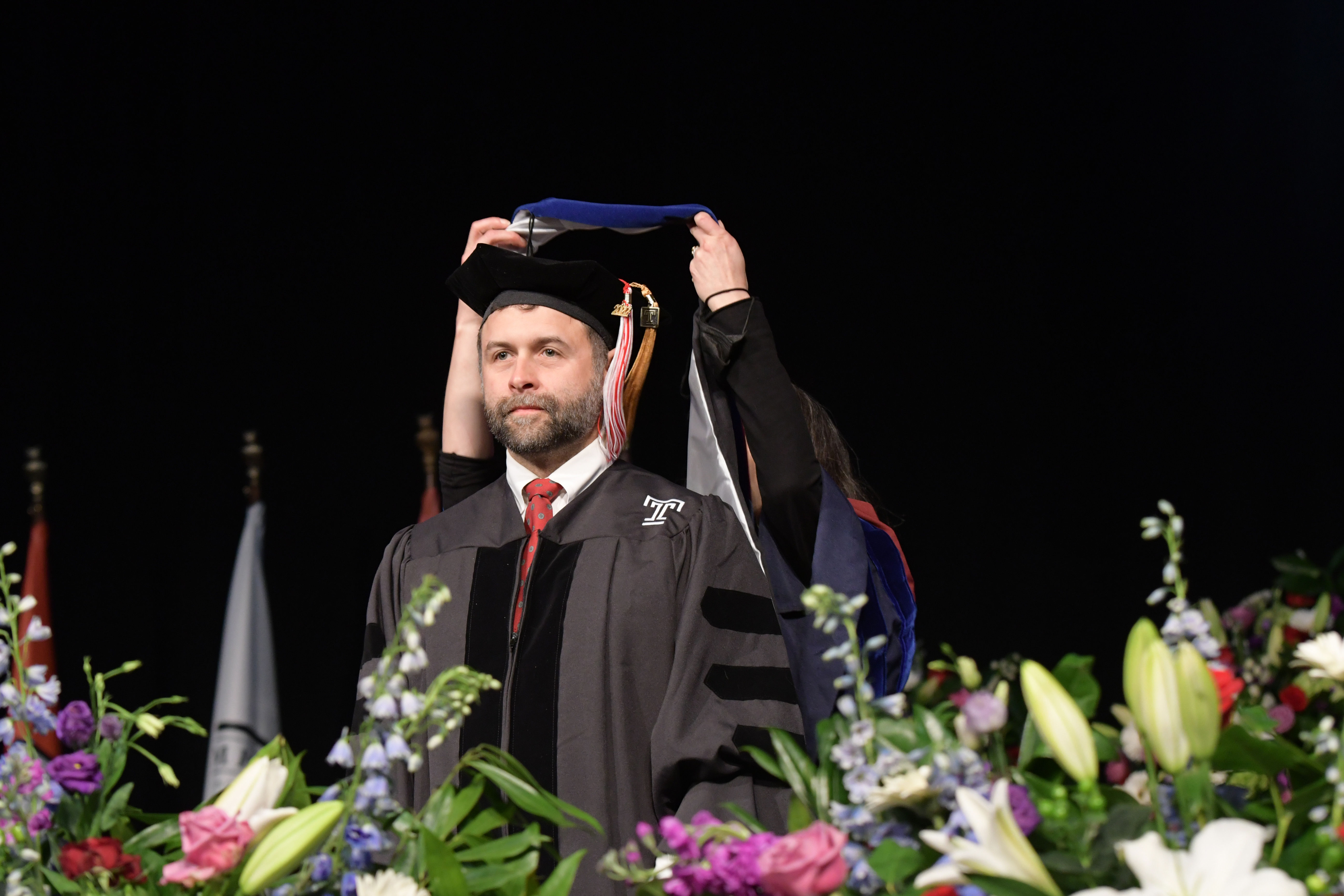 doctoral candidate receiving being hooded