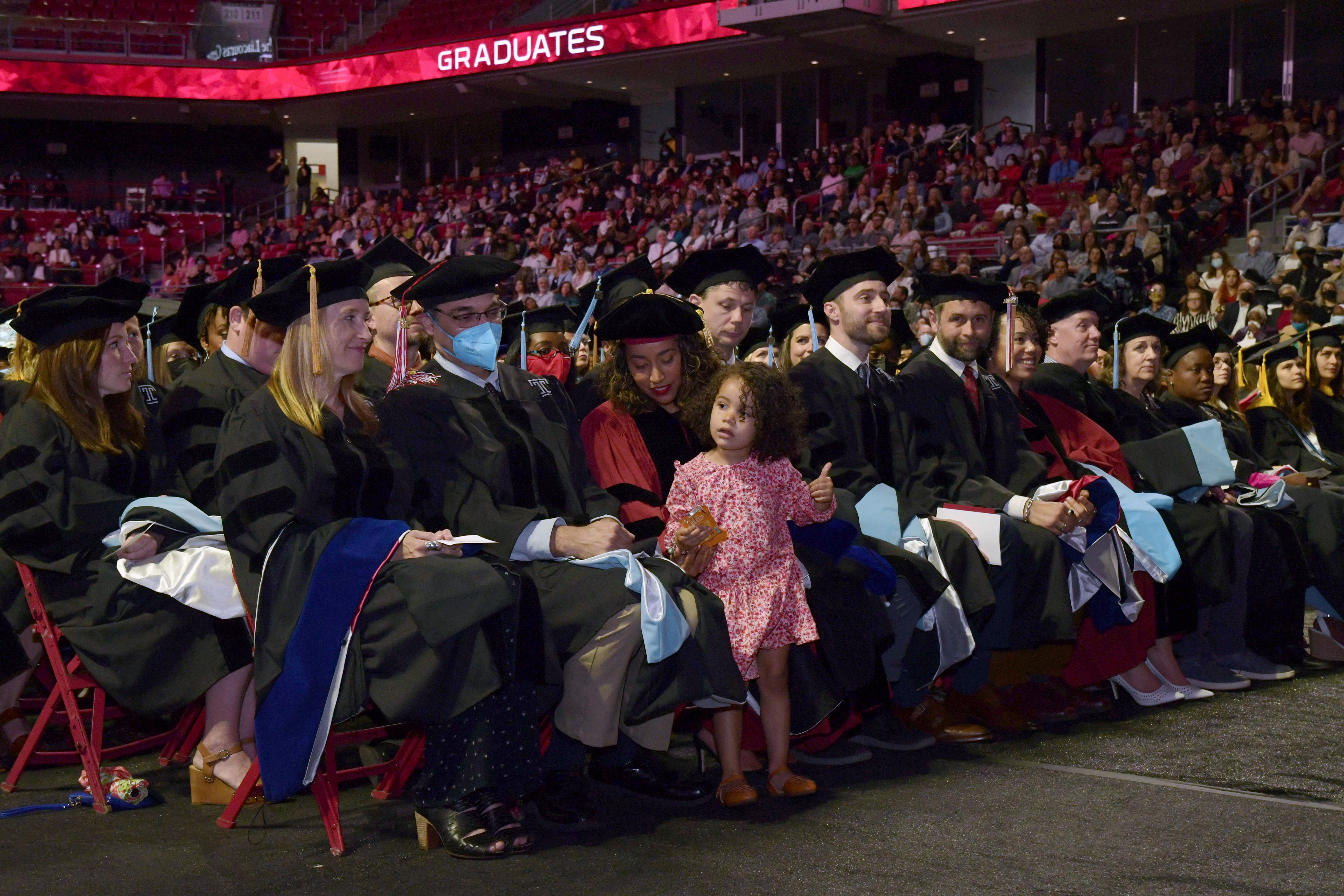 graduates seated in chairs on the arena floor