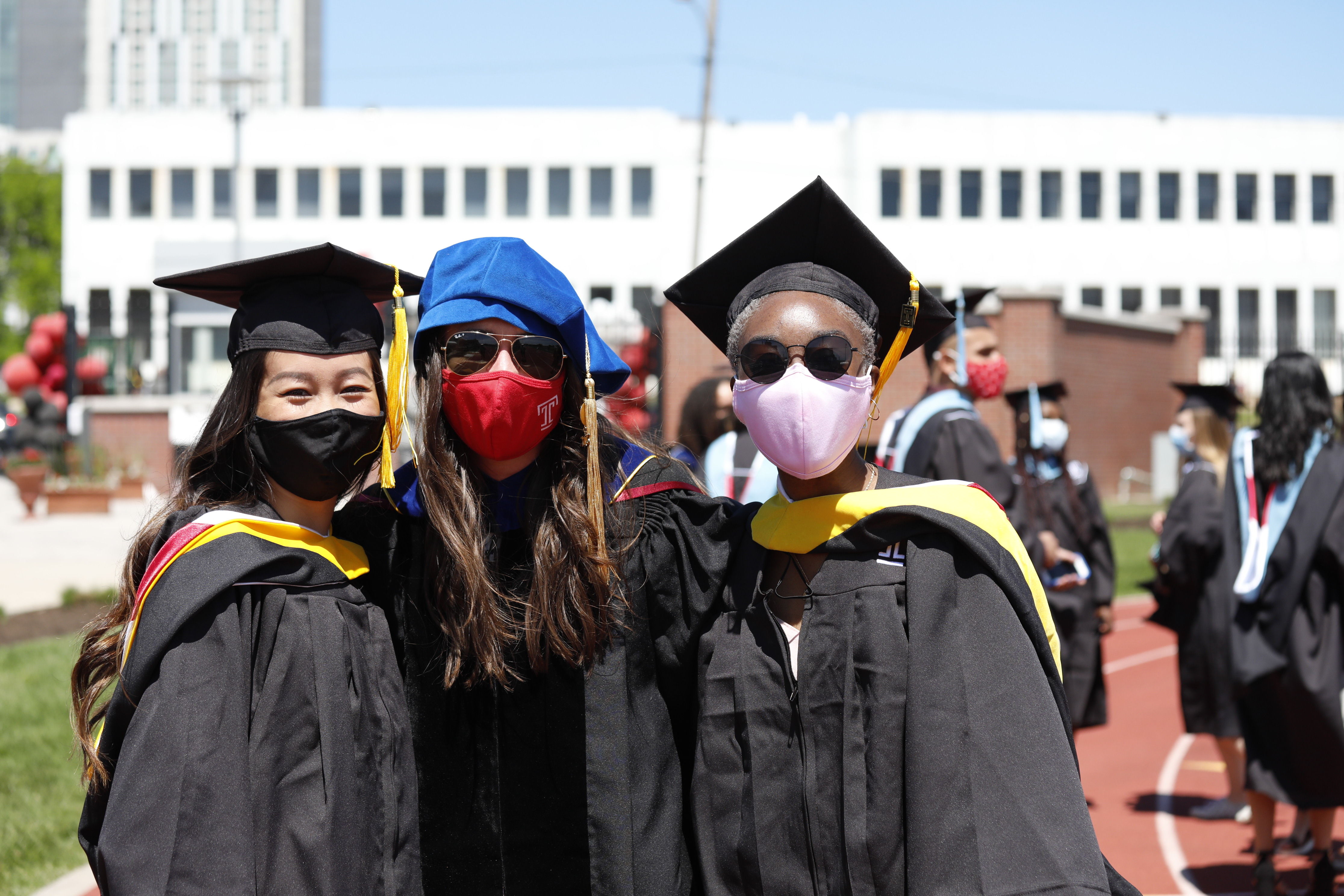 two graduates pose with professor