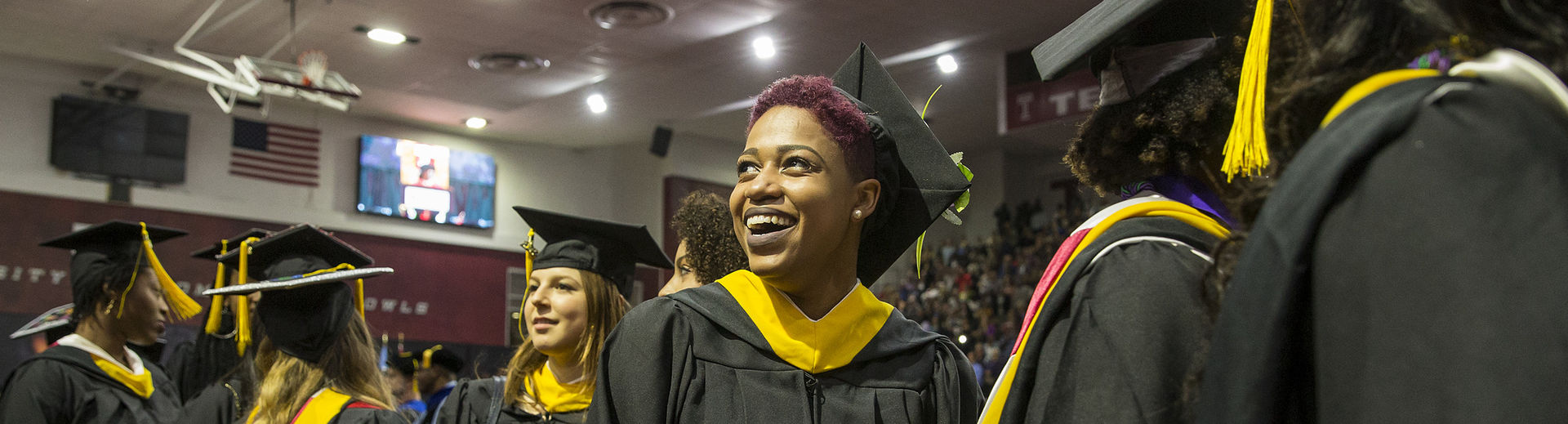 Temple graduates in cap and gown