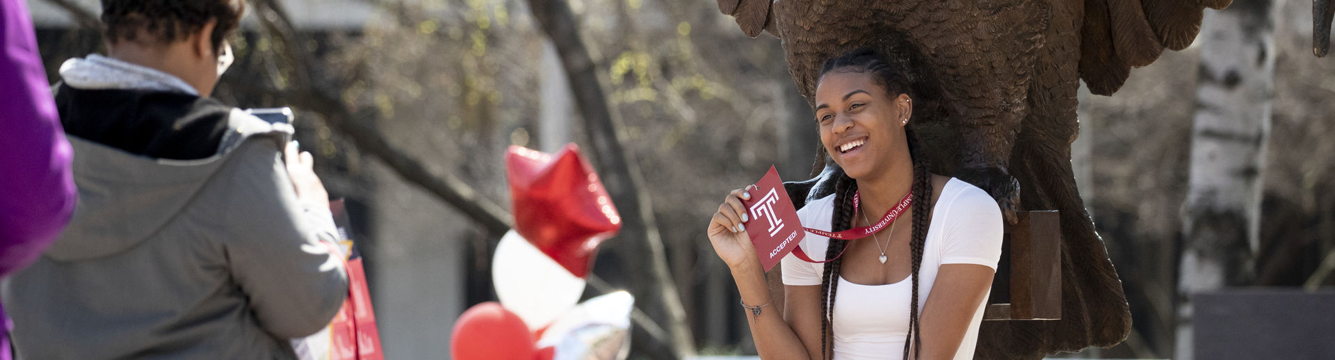 Admitted student sitting at Owl statue