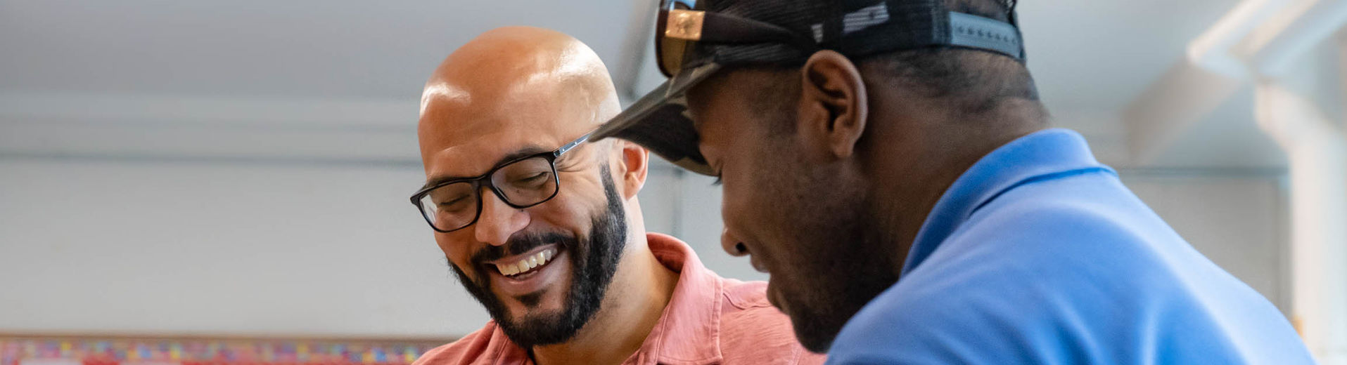Student teacher smiling with student in a classroom