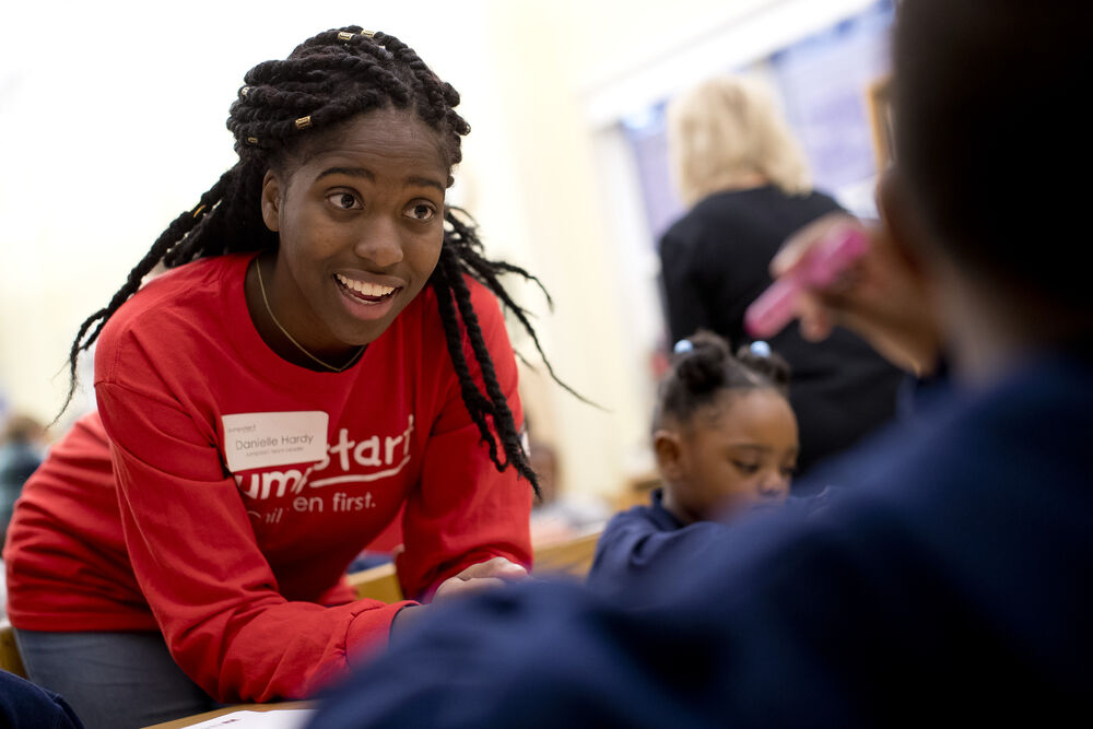 College student assisting a pre-school student