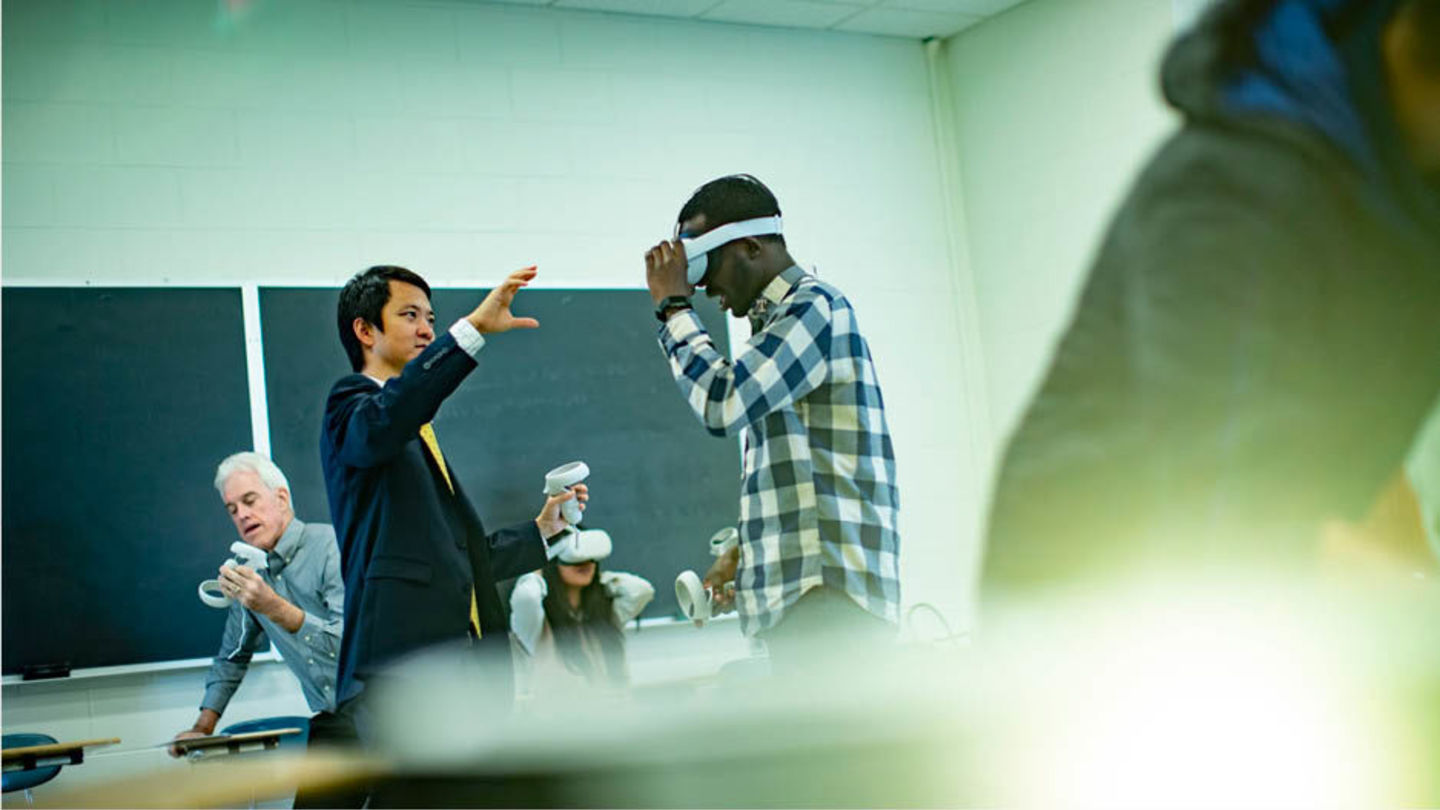 Professor Di Liu working with a student wearing a virtual reality headset during a demonstration