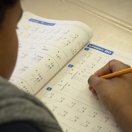 An elementary student who is working on a math homework. Feature image for the Kids in Crisis article.