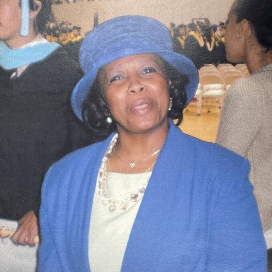 Valerie Williams in a light blue suit and hat. 